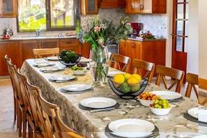 Una mesa de comedor dispuesta con platos, tazones y un florero.