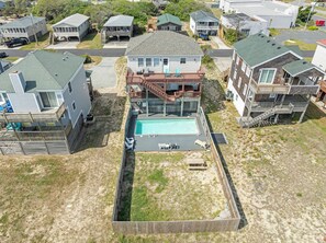 A residential area with multiple houses, a swimming pool, and a fenced yard. - Beach Bum'n: Private Pool | 3-Min Walk to Beach (Nags Head)