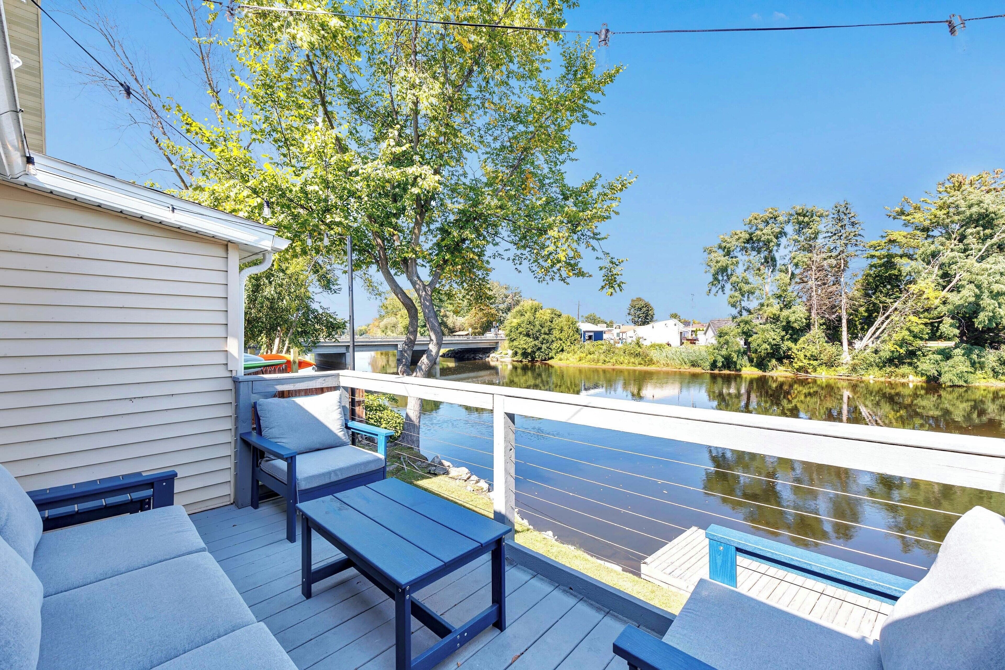 A deck with outdoor seating and a view of a river.