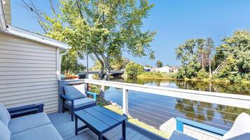 A deck with outdoor seating and a view of a river.