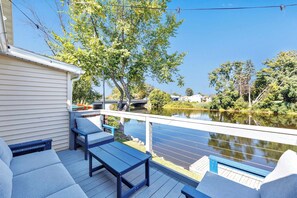 A deck with outdoor seating and a view of a river. - Lazy River Villa - Hottub! Fenced Yard! Sleeps 13! (Oconto)