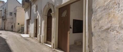 Un carrer estret amb edificis que tenen portals d'arc i portes de fusta.