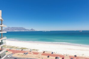 A coastal view with a beach, ocean, and distant mountains. - West Coast Horizon Retreat (Cape Town)