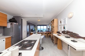 A modern kitchen with a central island, stainless steel appliances, and a view to the outside. - West Coast Horizon Retreat (Cape Town)