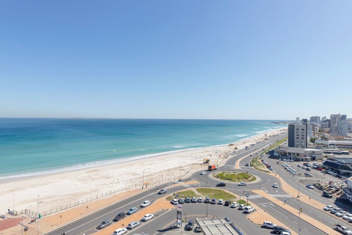 Un paisaje urbano costero con playa, carreteras y edificios.