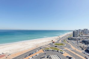 Een kuststadsgezicht met een strand, wegen en gebouwen.