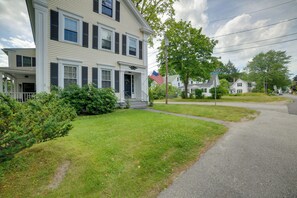 A two-story house with a porch and a flag. - Kennebunk Apartment w/ Local Beach Access! (Kennebunk)