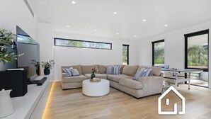 Ein modernes Wohnzimmer mit einem Ecksofa, einem Couchtisch und einem Esstisch.
