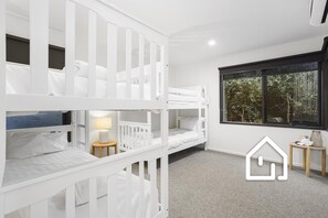 A room with bunk beds, a small table with a lamp, and a window with a view of trees. - Cambridge Gardens *1 NIGHT FREE* Luxury in Sorrento with Spa & Solar Heated Pool (Sorrento)
