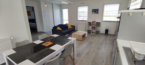 Un salon moderne comprenant une table à manger, un canapé et un espace de jeux pour enfants.