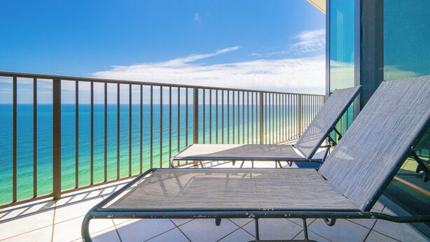 A balcony with two sun loungers overlooking the ocean. - The Oasis at Orange Beach, formerly known as Phoenix West II, Unit 2103 (Orange Beach)