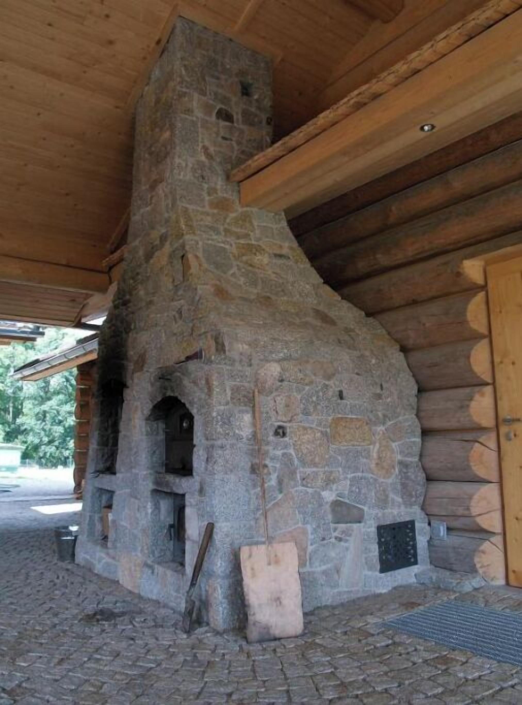Une cheminée en pierre avec une structure de toit en bois.
