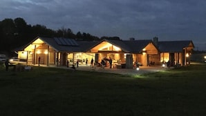 A log cabin-style building with multiple rooms and a covered outdoor area. - Quadruple Room with Bathroom (Sciegny)