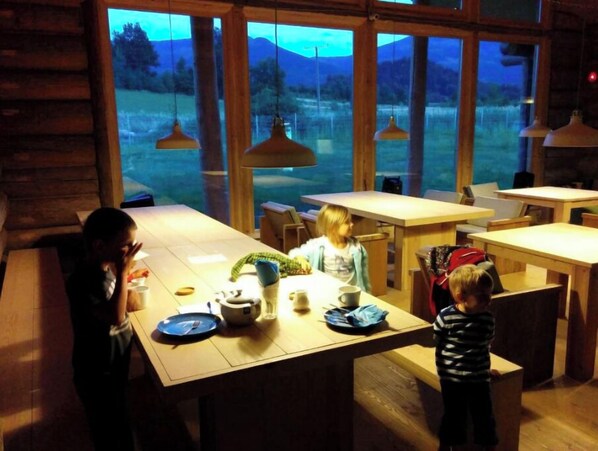 Enjoy meals in a serene mountain setting with a view, surrounded by natural beauty and warm ambiance.