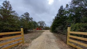 A gravel path leading to a red building surrounded by trees. - Country Living with Kyle Field 30 minutes away (SOMERVILLE)