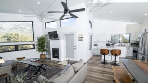 A spacious living area with a sofa, coffee table, and a large window offering a mountain view.