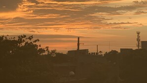 Un tramonto con sullo sfondo il profilo di una città.