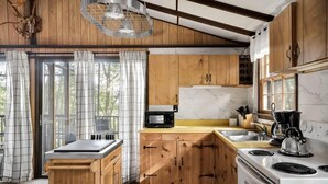 A kitchen with wooden cabinets, a white stove, and a microwave. - Secluded Cabin: Hot Tub, Huge Deck, Fire Pit, WiFi (Hedgesville)