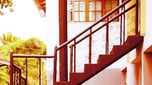 Un escalier avec une rampe en fer forgé menant à un niveau supérieur.