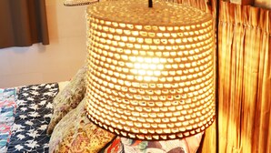 Un lit avec une couvre-lit à motifs, une lampe décorative et une tête de lit en bois.