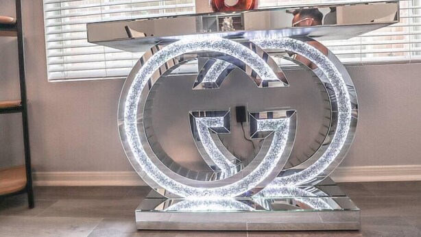 A modern, illuminated Gucci logo table in a room with large windows and a decorative vase. - Modern 5 Bedroom, 3 Full bathroom, + PlayStation. (Montgomery County)