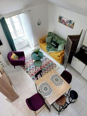 Un salon moderne avec un canapé, une table à manger et des chaises.