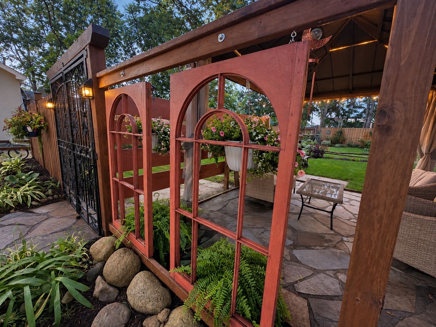 Un espace patio agrémenté d’une pergola en bois, d’un revêtement de sol en pierre et d’un aménagement avec des sièges.