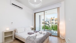 Una camera da letto moderna con un letto, comodini, un termosifone e vista sull'esterno.