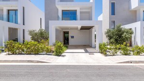 Un edificio moderno con un ingresso centrale, ampie finestre e un tetto piatto.