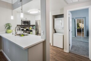 A modern kitchen with white cabinetry, stainless steel appliances, and a central island with a sink. - Lovely 1-bedroom Apartment In Great Location. (Roseville)
