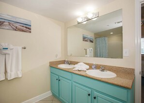A bathroom with two sinks, a large mirror, and a painting on the wall. - Sanibel by ALBVR (Gulf Shores)