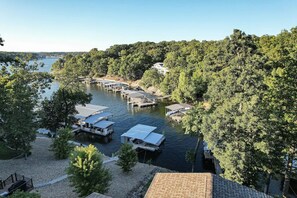 A lakeside property with docked boats, a gazebo, and a gazebo with a covered patio. - Centrally Located~3 Floors~Private Dock~Sleeps 16~ Waterfront-Lots of Outdoor Space- Lilly Pad (Osage Beach)