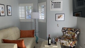 A living room with a beige sofa, a patterned armchair, a coffee table, and a ceiling fan. - Your Oasis Retreat: Pool, style, comfort, relaxation (Phoenix)