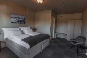 A bedroom with a bed, a chair, a desk, and a wardrobe. - Aksdal Inn Motell (Tysvaer)