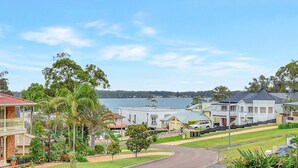Zona residencial con casas, una carretera y un lago al fondo.