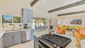 Una cucina moderna con piano cottura a gas, mobili grigi e vista sulla zona esterna.