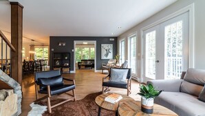 Un salon spacieux doté d’une cheminée, d’une grande fenêtre et offrant une vue sur l’extérieur.