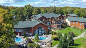A resort with multiple buildings, outdoor pools, and a well-maintained landscape. - Lakeside Chalet, Sauna, Mont Orford & Village (Eastman)