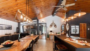 A spacious kitchen with wooden countertops, a central island, and pendant lighting. - Le Cozy-St-Côme: Private Lake, Spa & Nature at Val St-Côme (Saint-Côme)
