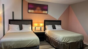 Een hotelkamer met twee enkele bedden, een nachtkastje met een lamp en een schilderij aan de muur.