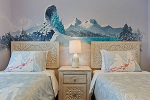 A bedroom with two beds, a nightstand with a lamp, and a mural of a mountainous landscape on the wall. - 5-bedroom townhome with a screened plunge pool at Solterra Resort, near Disney (Davenport)