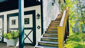 A staircase leading to a white building with dark trim and a metal gate. - Waterfront Splendor in the Woods. (Florence)