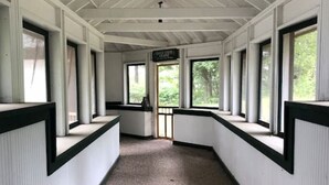 A corridor with white walls, black trim, and large windows. - Waterfront Splendor in the Woods. (Florence)