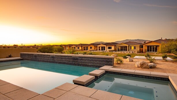 A swimming pool with a tiled deck, a hot tub, and a view of a residential area with houses and mountains in the background. - Chimayo House with Pool and Spa near Palm Springs - Sleep 6 (Cathedral City)