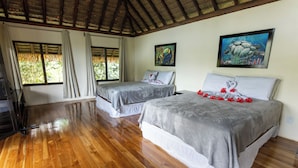 Ein Zimmer mit zwei Betten, Holzboden und einem Reetdach.