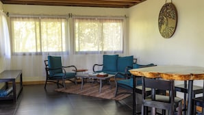 Ein Zimmer mit einer Couch, Sesseln, einem Tisch und einem Wanddekor.