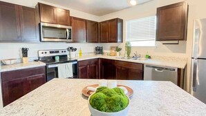 Una cocina moderna con armarios de madera oscura, electrodomésticos de acero inoxidable y encimera de granito.