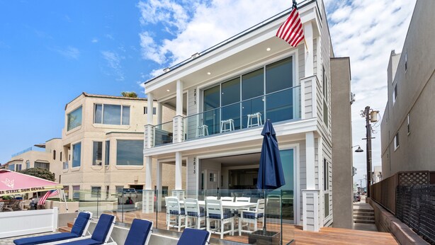 Ein modernes Gebäude mit Balkon, Liegestühlen und einer US-amerikanischen Flagge.