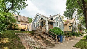 A residential house with a front porch, a staircase leading to the entrance, and a small front yard. - East Side Spa Retreat Near Lake, Restaurants and Fun (Milwaukee)