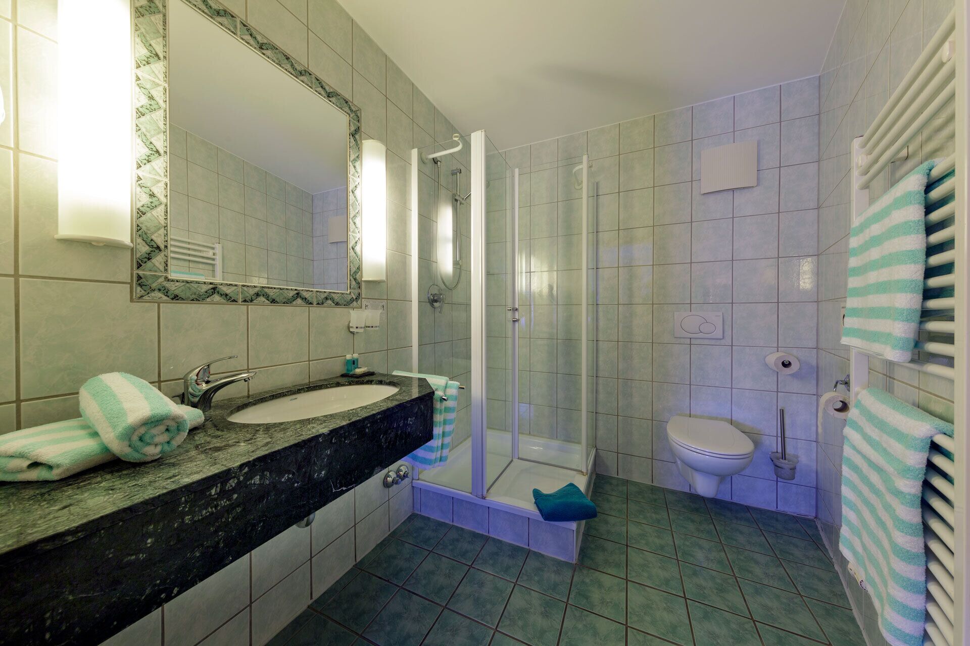 Une salle de bain avec deux lavabos, une douche et des toilettes.